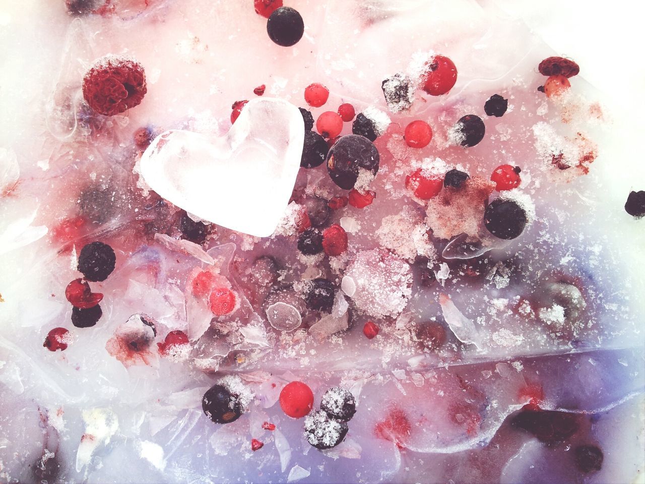 Frozen heart shape ice and berries
