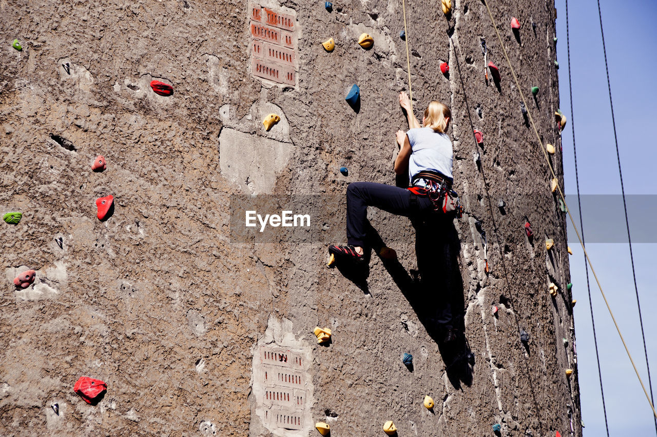 Low angle view of woman rock climbing