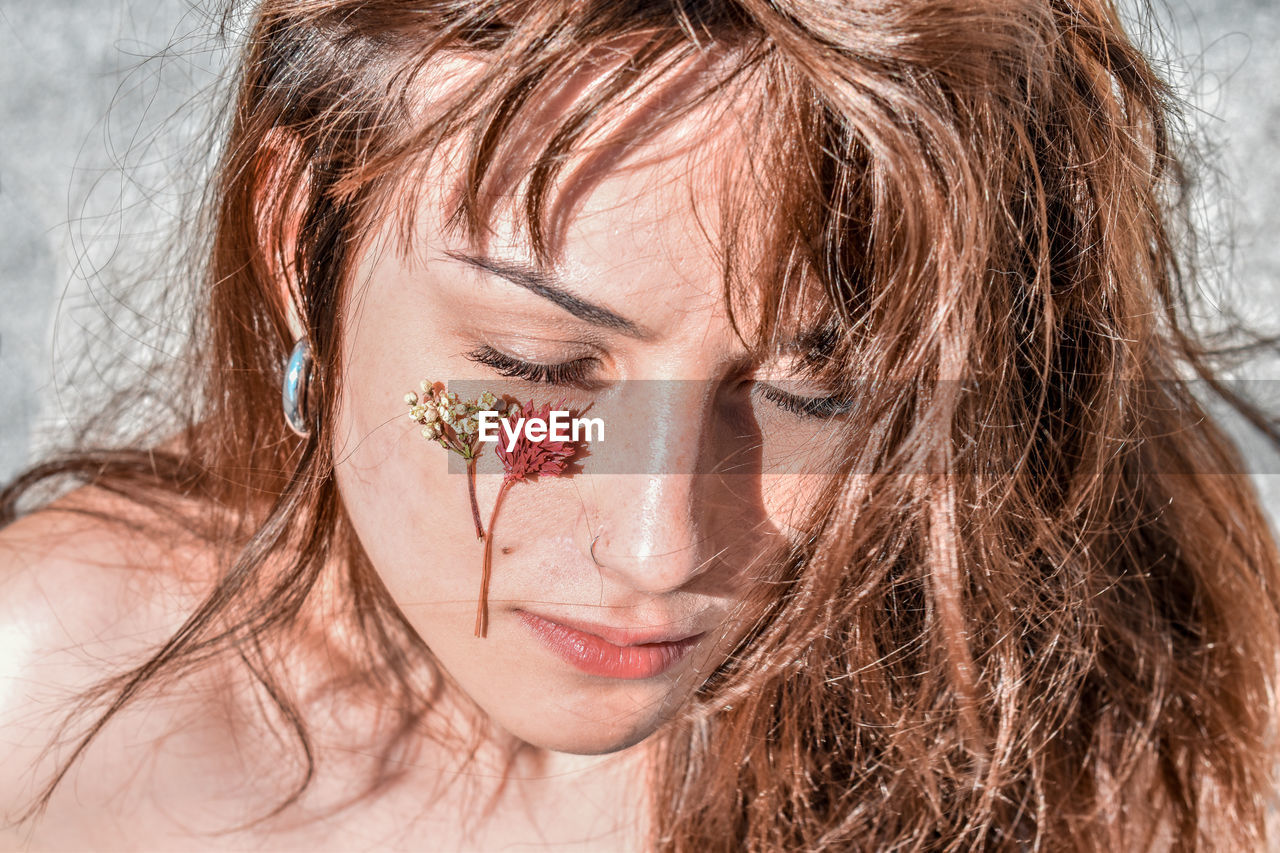 Close-up of woman with flowers on cheek