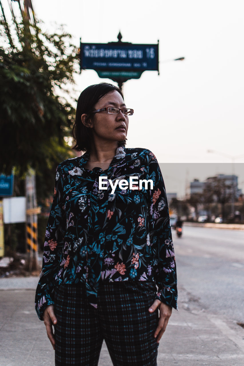 Woman looking away while standing outdoors