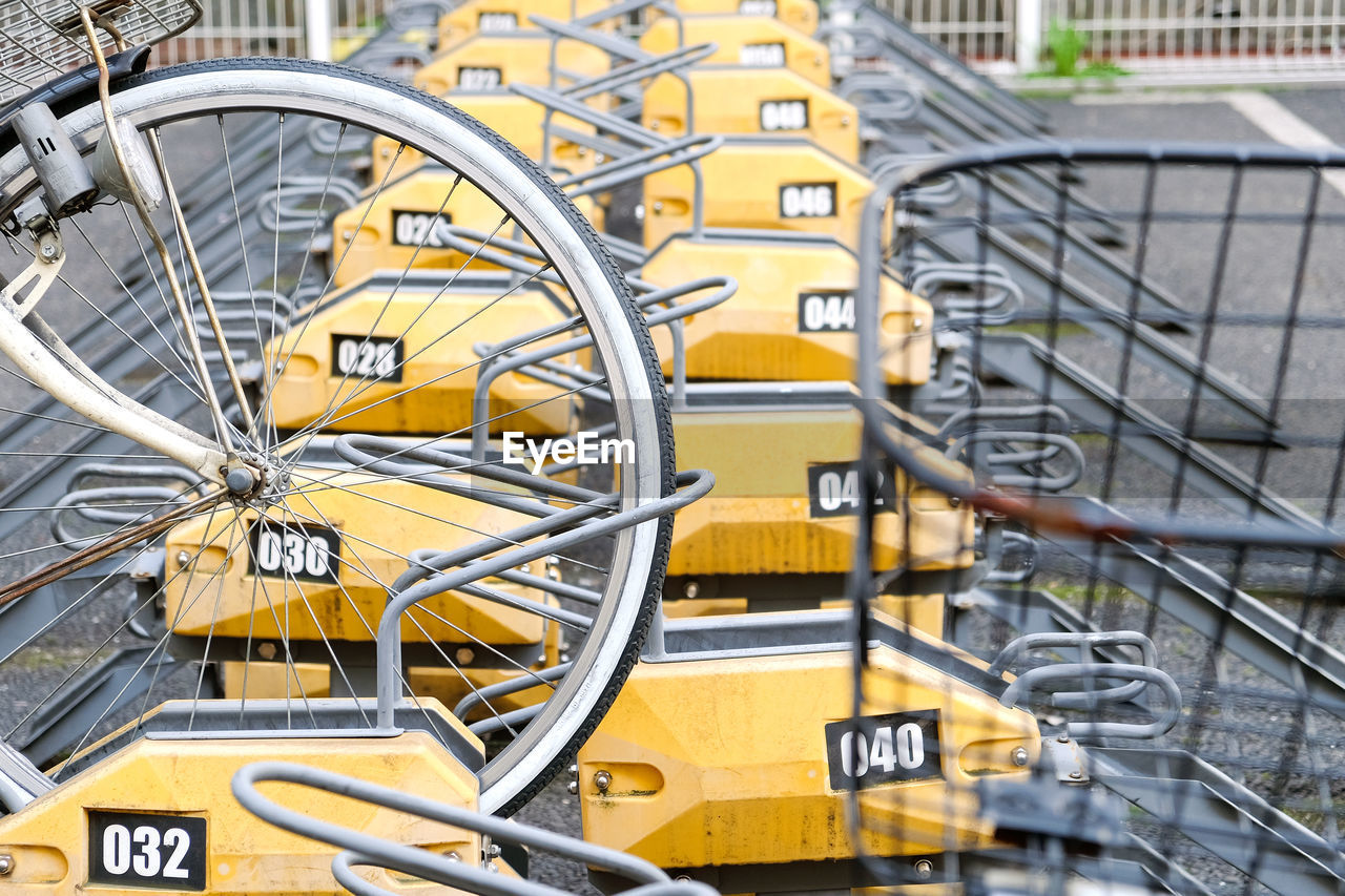 CLOSE-UP OF BICYCLE PARKED AGAINST METAL