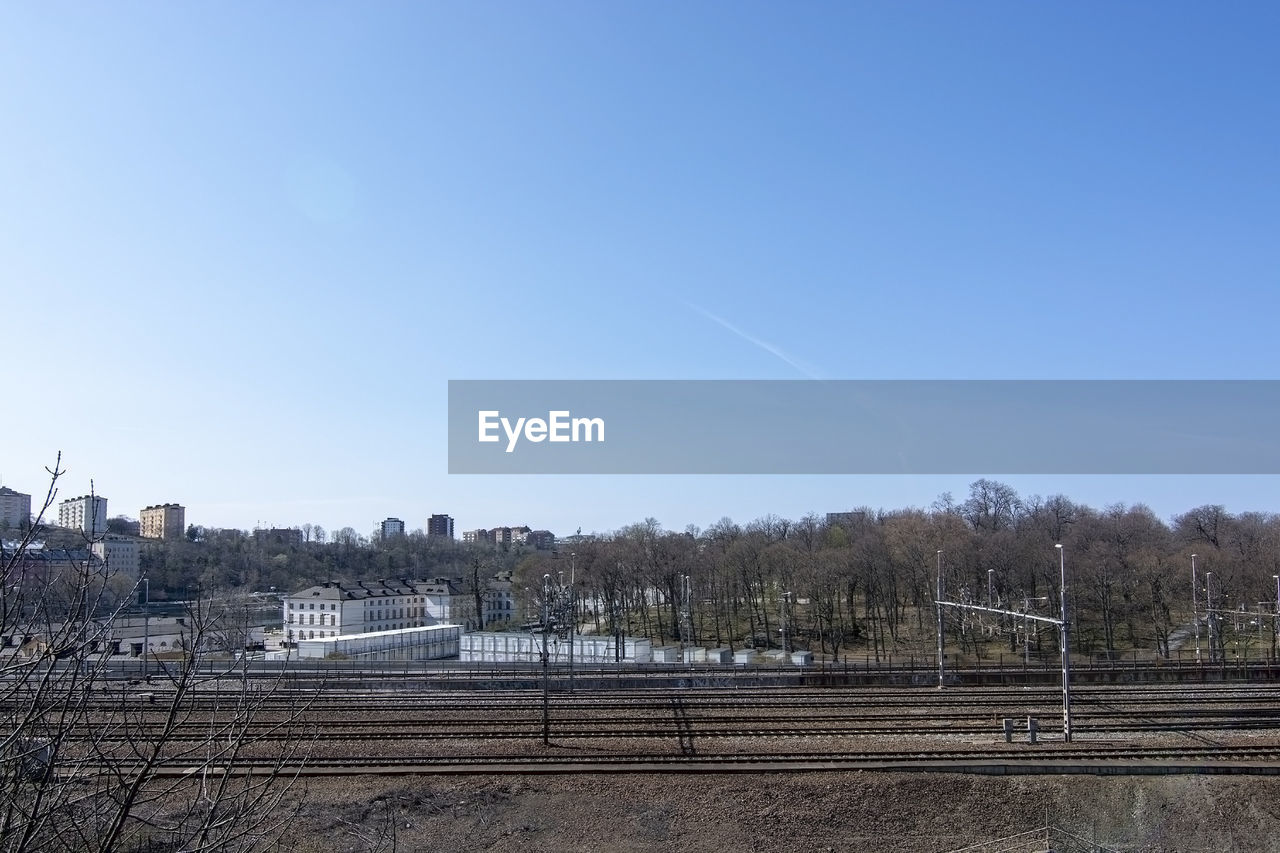 RAILROAD TRACKS AGAINST CLEAR BLUE SKY