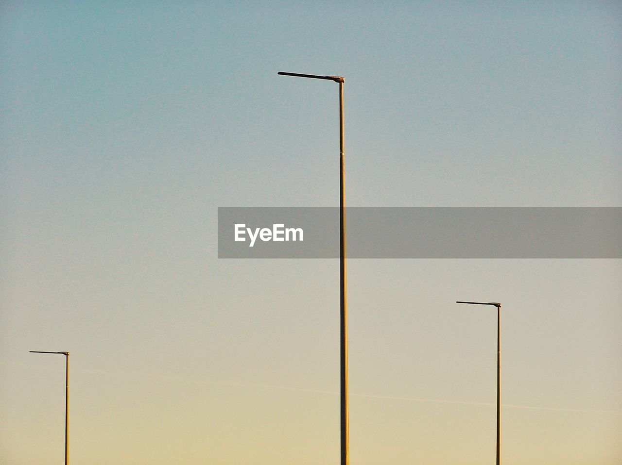 LOW ANGLE VIEW OF WINDMILL AGAINST CLEAR SKY DURING SUNSET