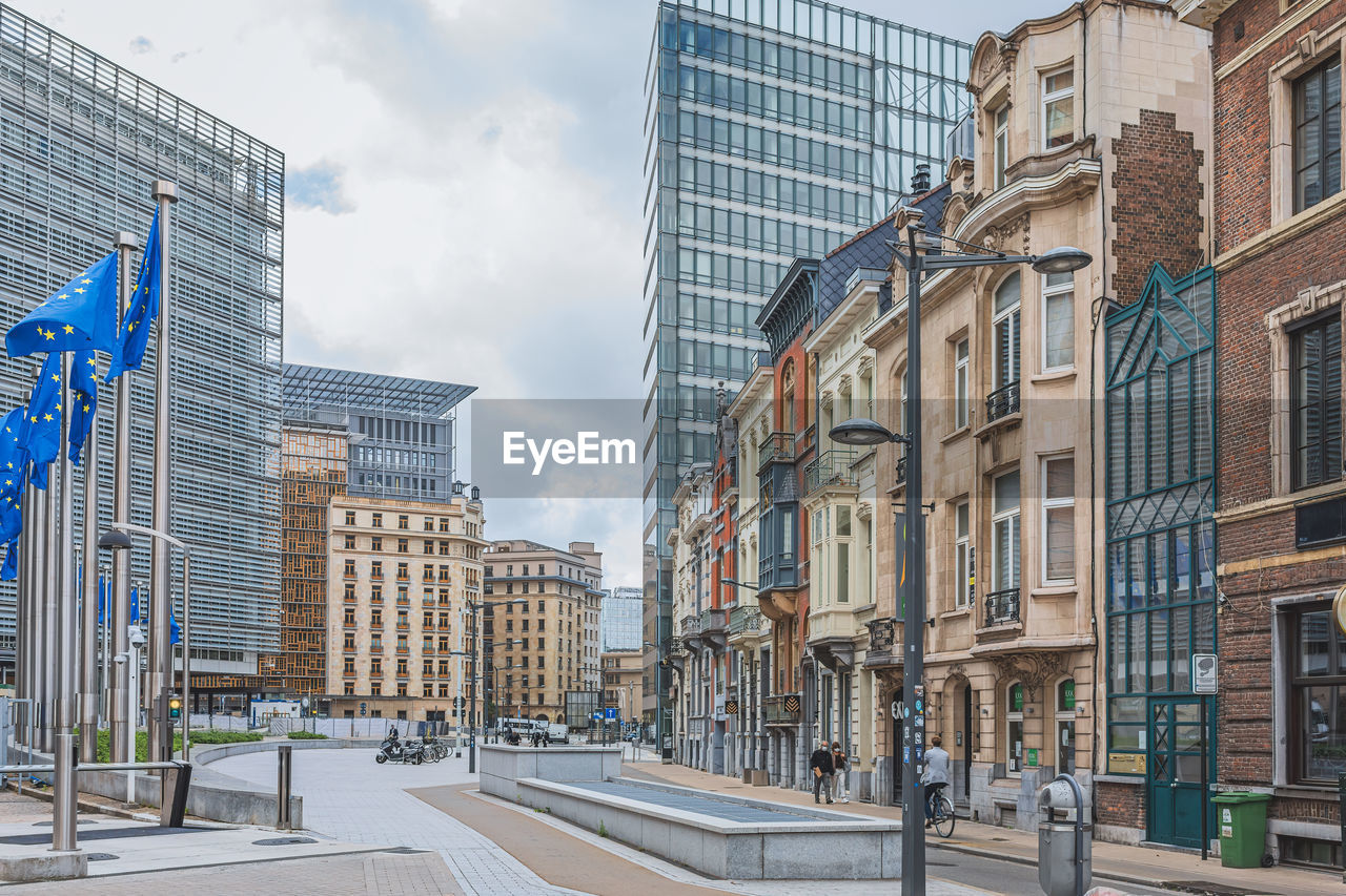 LOW ANGLE VIEW OF BUILDINGS BY STREET AGAINST SKY