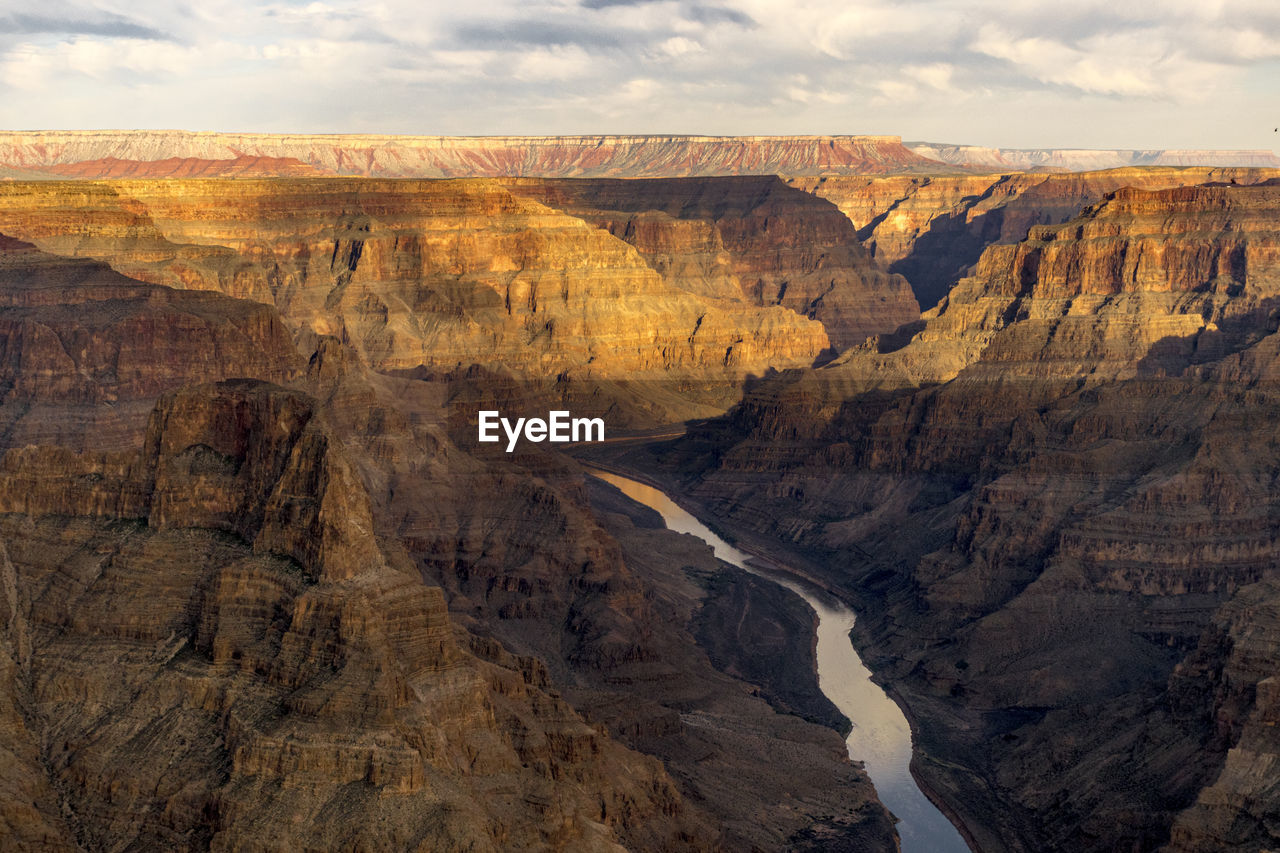 Scenic view of rock formations against cloudy sky