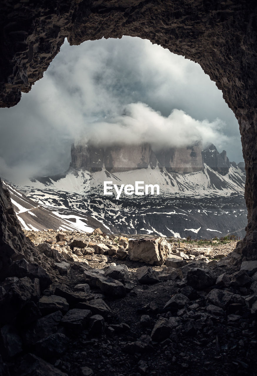 Scenic view of mountain against sky seen through cave