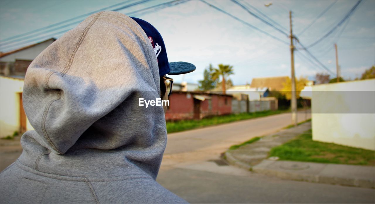 CLOSE-UP OF MAN WEARING HAT AGAINST SKY