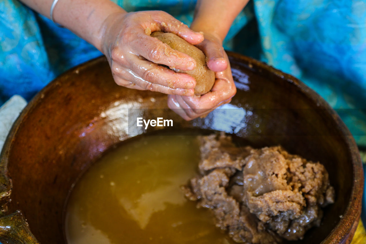 Close-up of moroccan amazigh woman hands squeezing argan paste