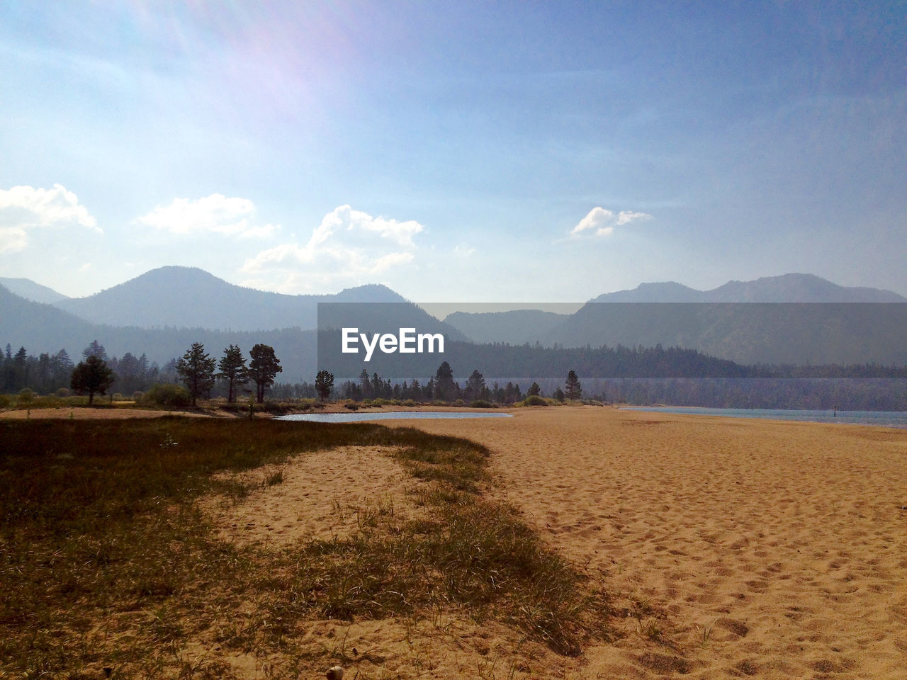 Beach by mountains against sky