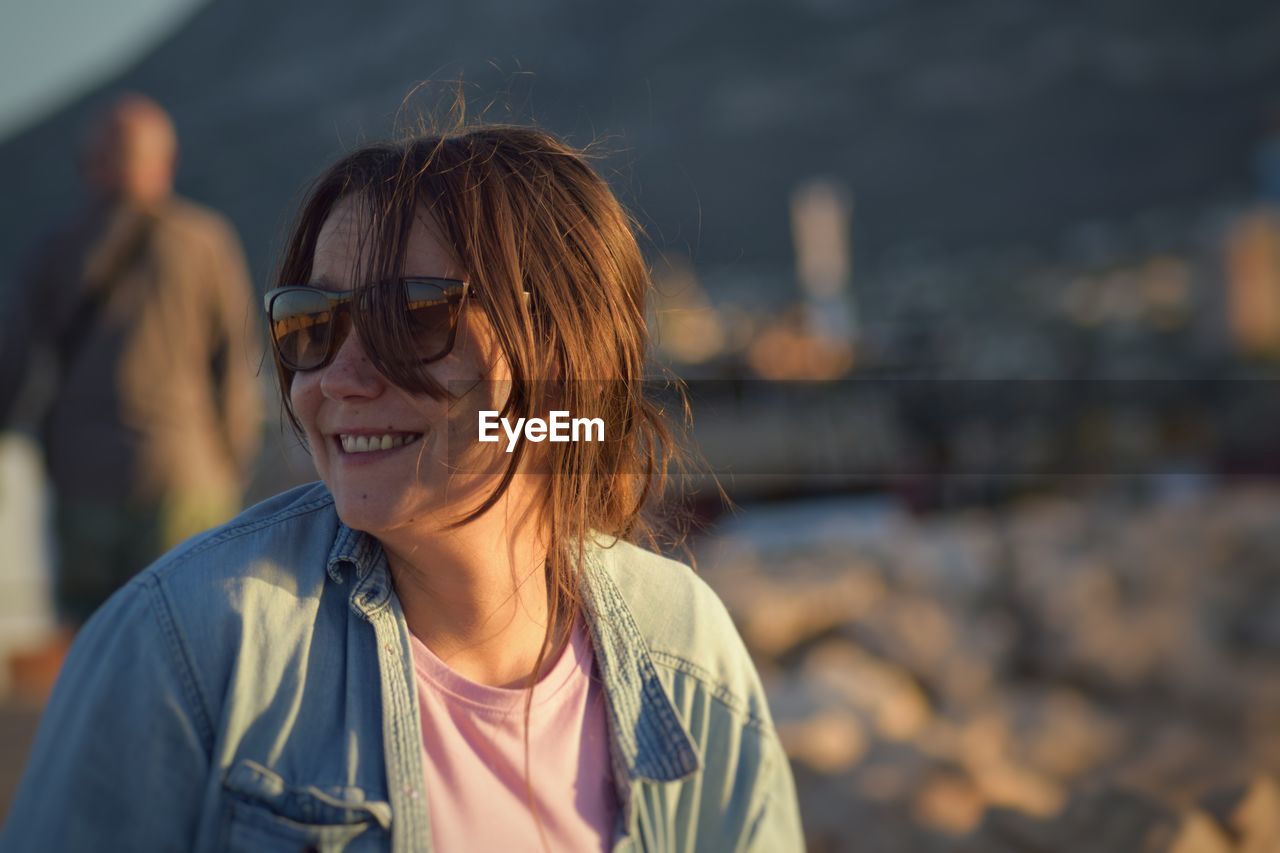 Close-up of woman wearing sunglasses during sunset