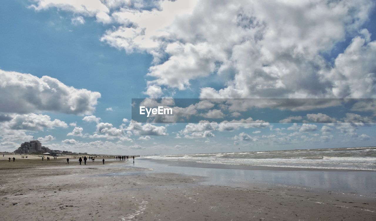 Scenic view of beach against cloudy sky