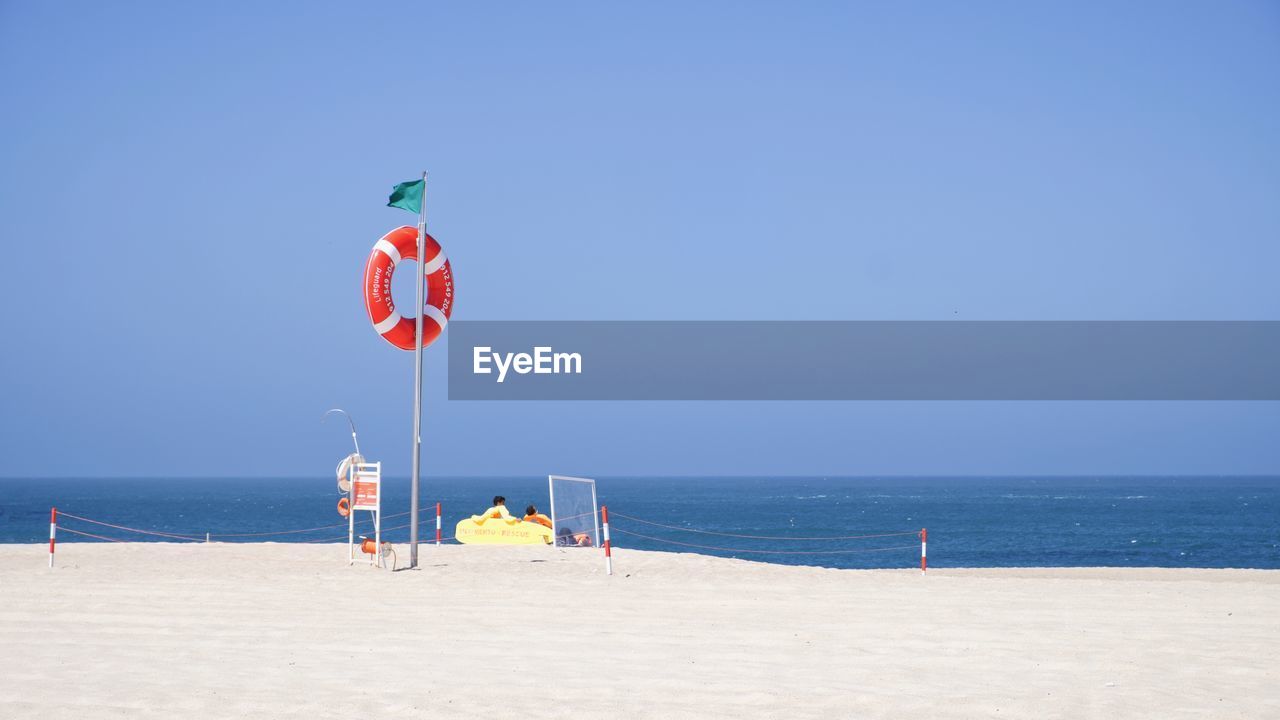 FLAG ON BEACH AGAINST SKY