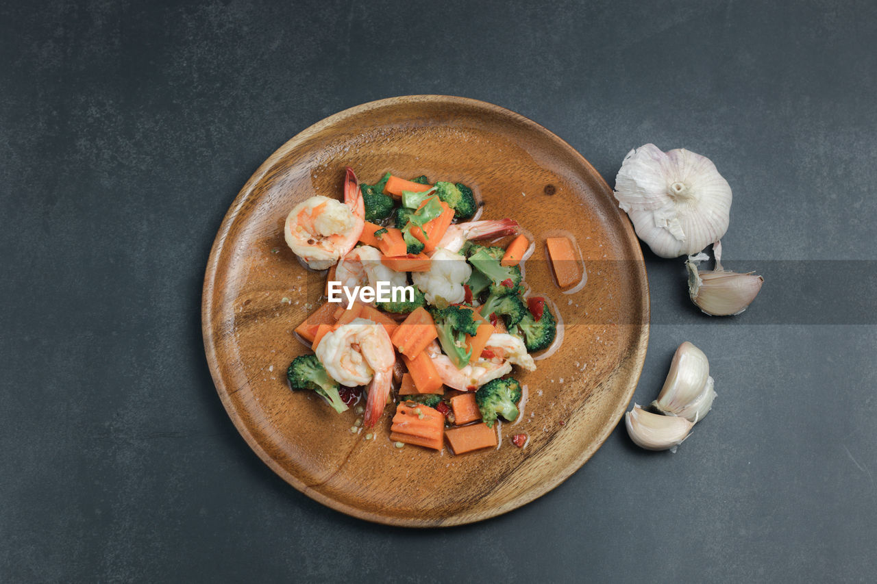Stir-fried broccoli and shrimp on a black background