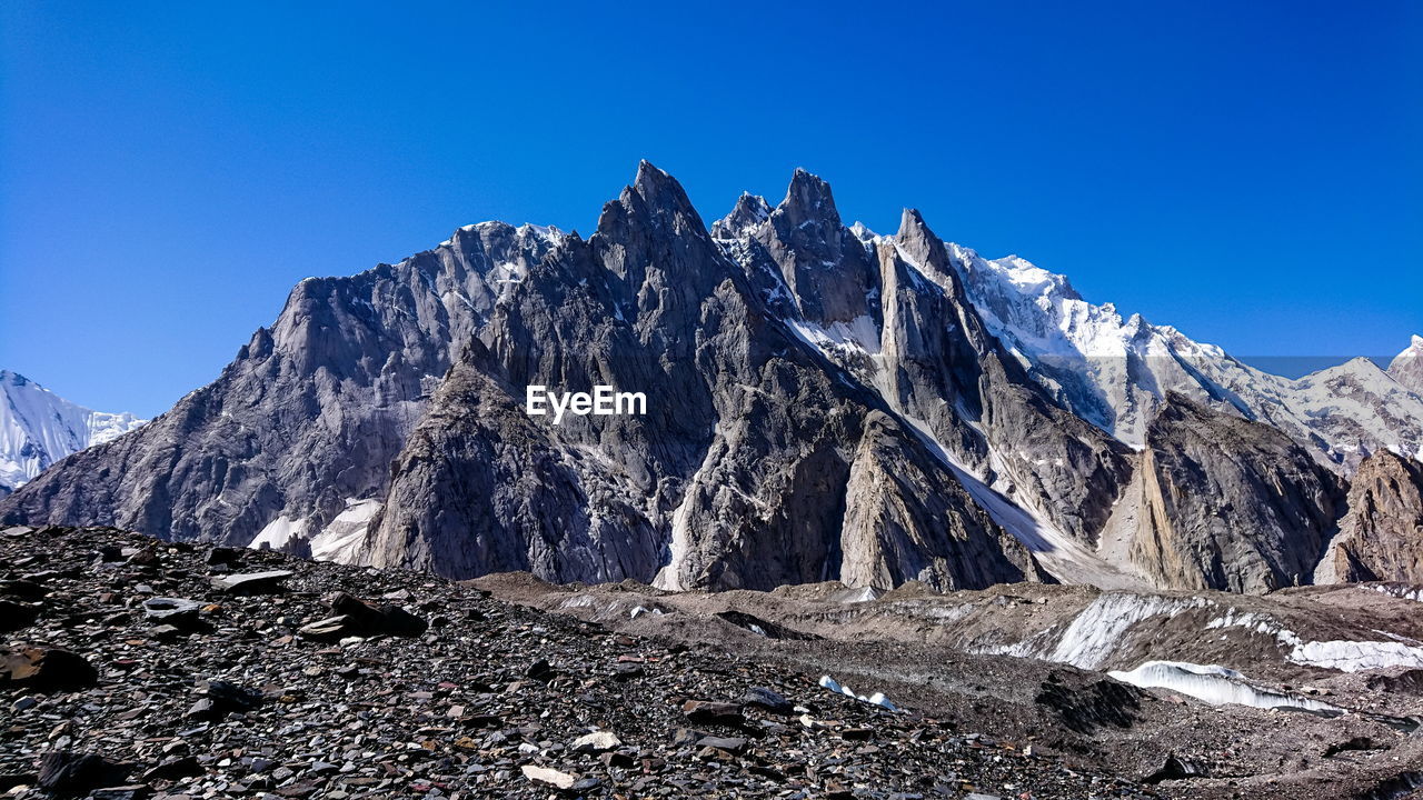 Scenic view of snowcapped mountains against clear blue sky