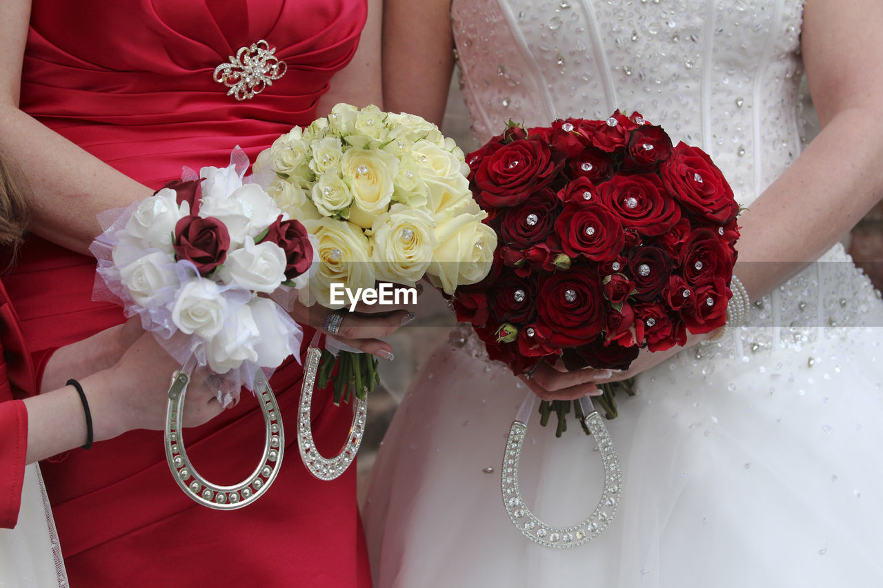 CLOSE-UP OF HAND HOLDING BOUQUET OF ROSES