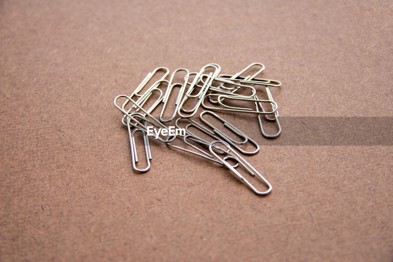 Close-up of paper clips on brown table