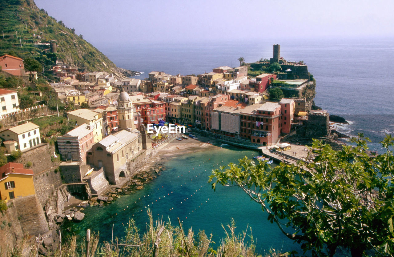 High angle view of town by sea against sky