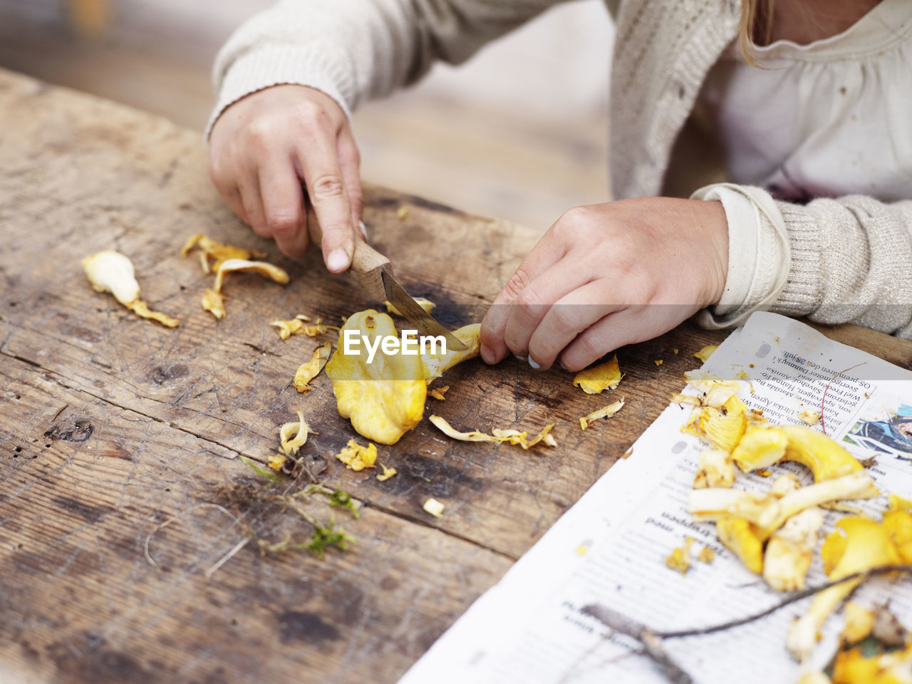 Girl cutting chanterelle, close-up