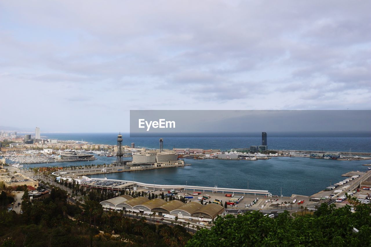 High angle view of cityscape by sea against sky