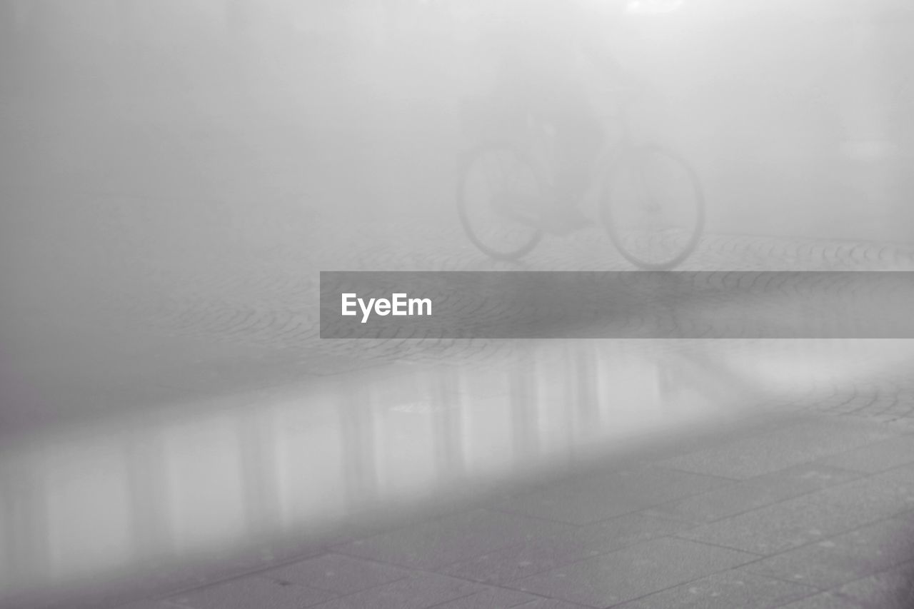 Person riding bicycle on street during foggy weather