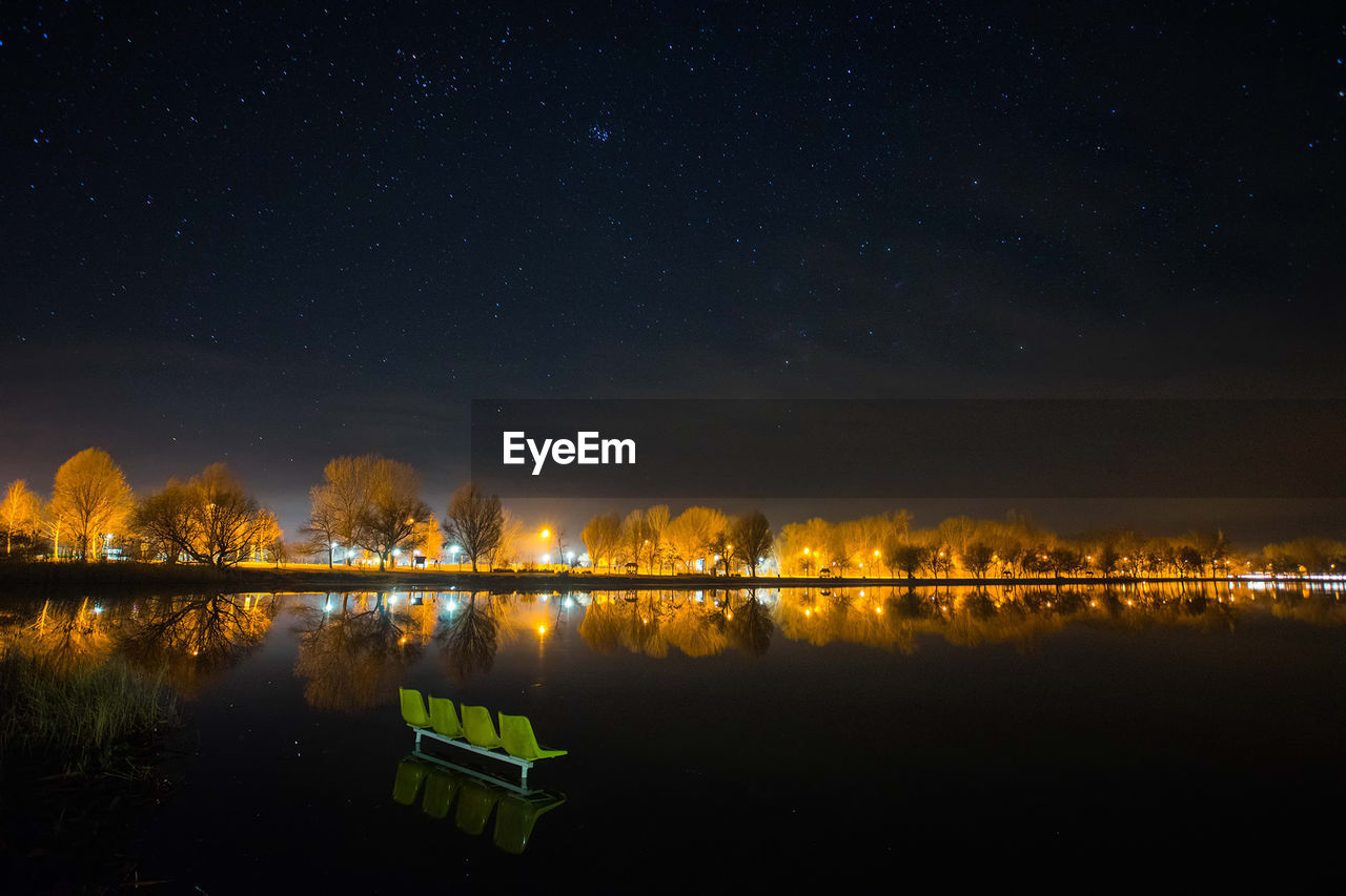 Scenic view of lake against sky at night