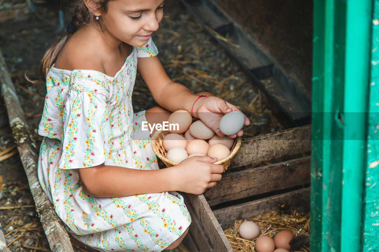 Cute girl holding eggs in basket
