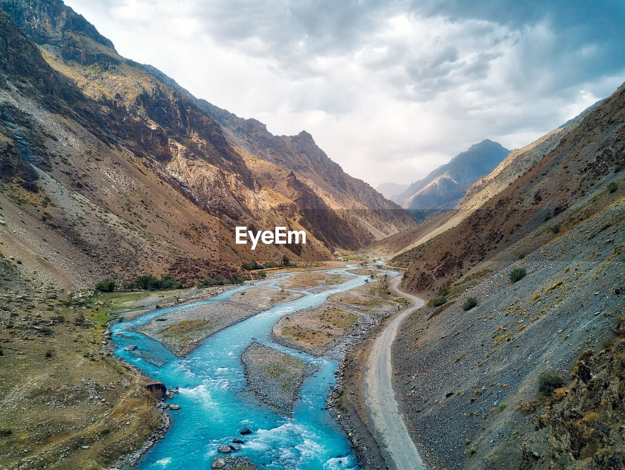 High angle view of river amidst mountains against sky