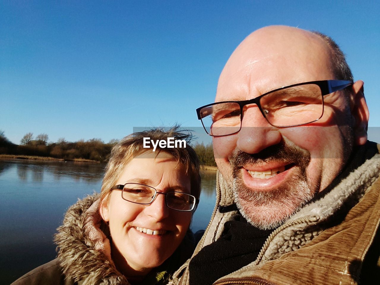 Portrait of smiling couple against sky