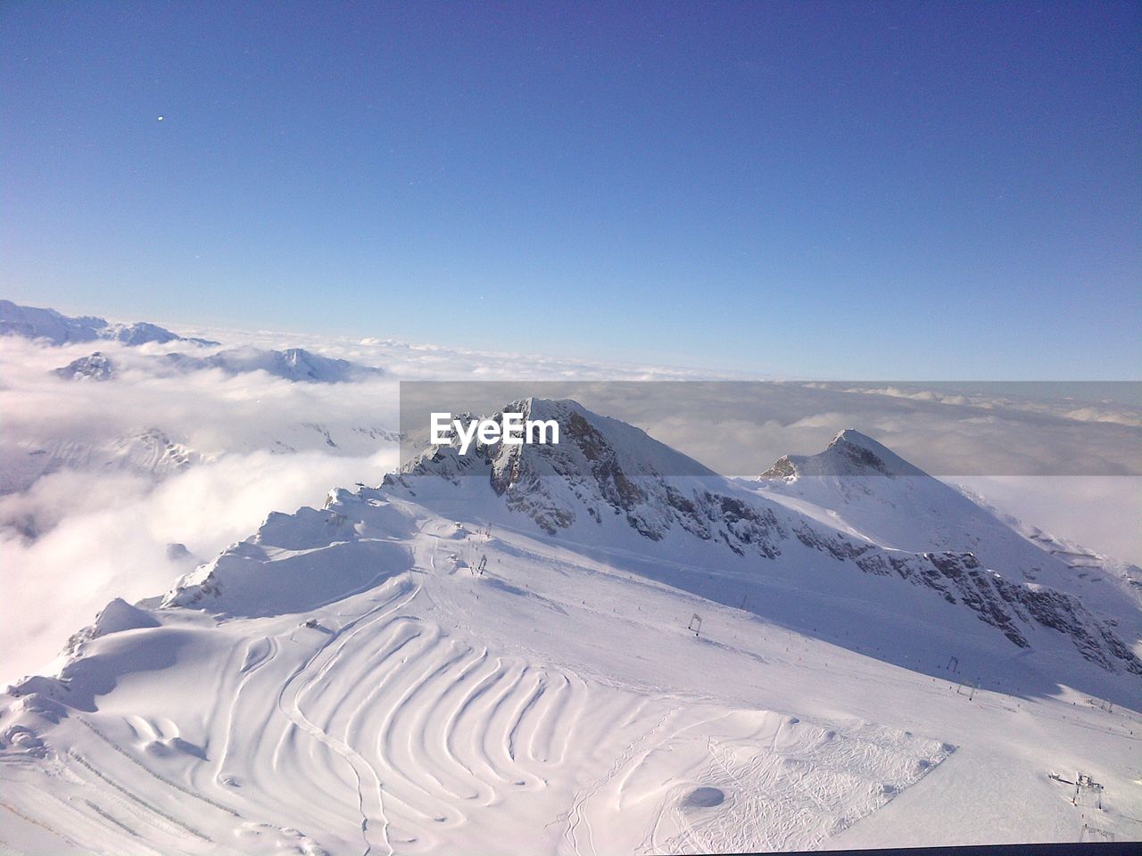 Scenic view of snowcapped mountains against blue sky