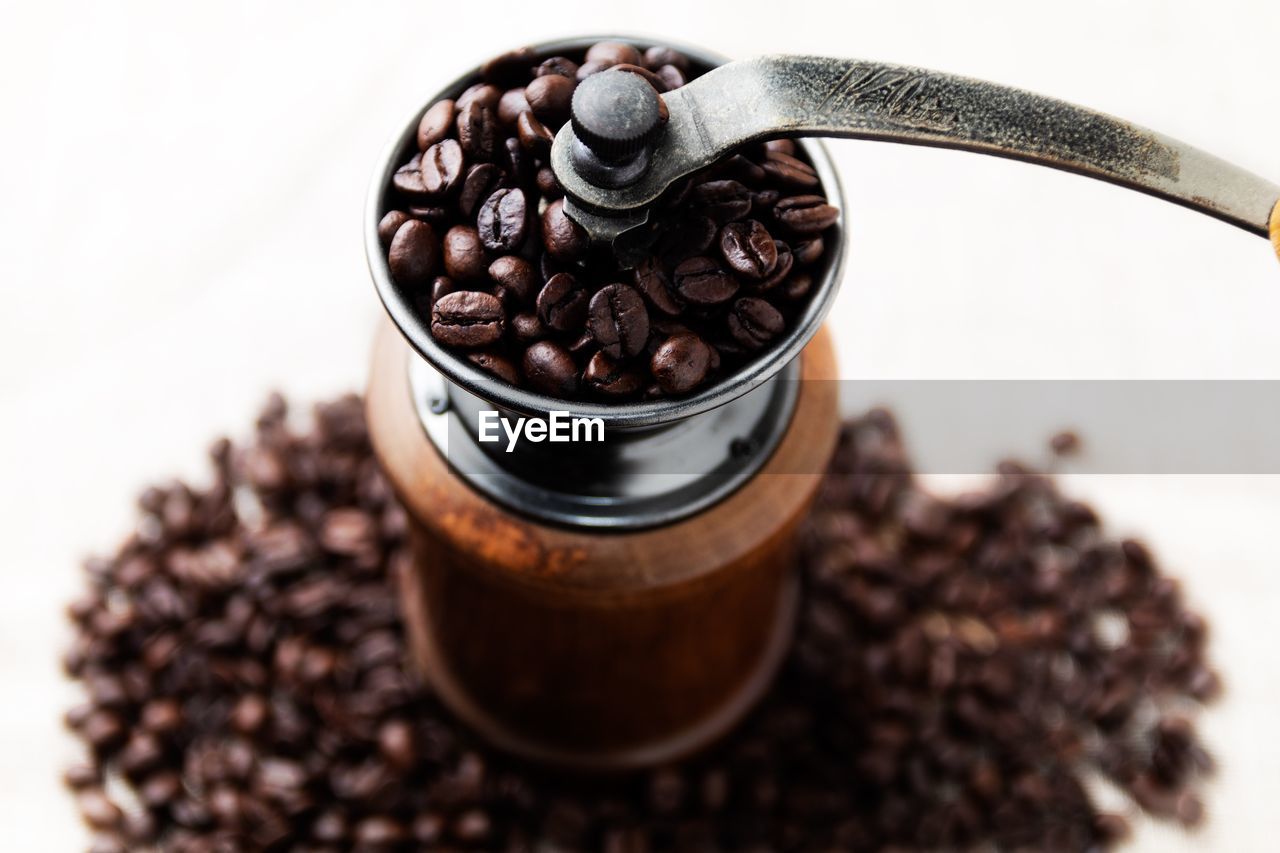 High angle view of coffee beans in grinder on white background