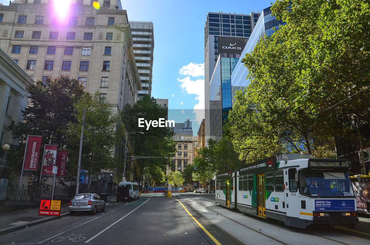 Cars on city street against sky