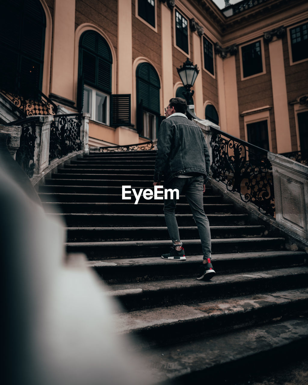 FULL LENGTH REAR VIEW OF MAN WALKING ON STAIRCASE OF BUILDING