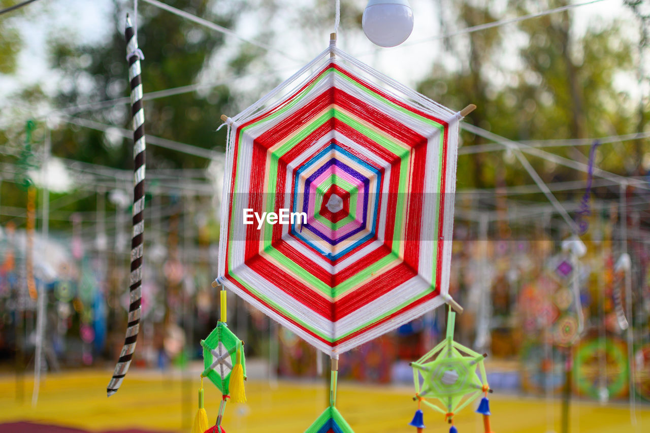 CLOSE-UP OF MULTI COLORED TOY HANGING ON TREE