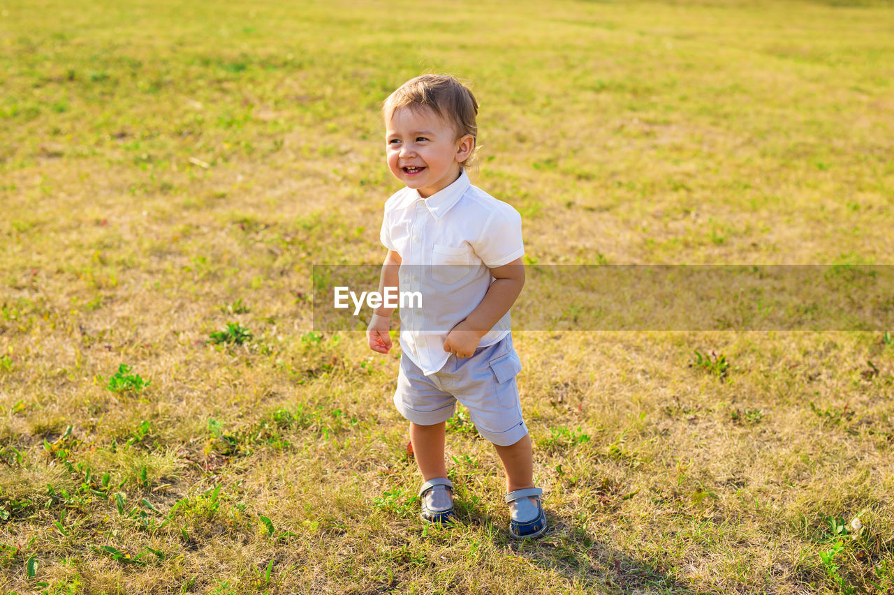 Portrait of smiling boy standing on grass