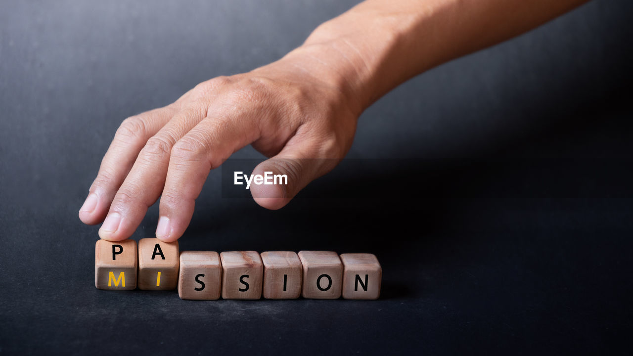 hand, close-up, indoors, one person, studio shot, finger, text, business, adult, number, game, finance