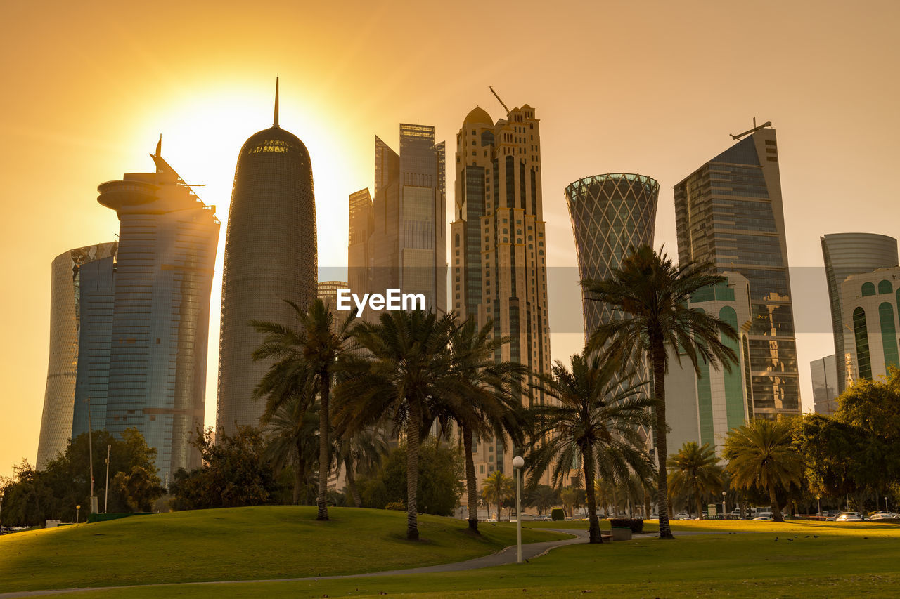 Modern buildings against sky during sunset