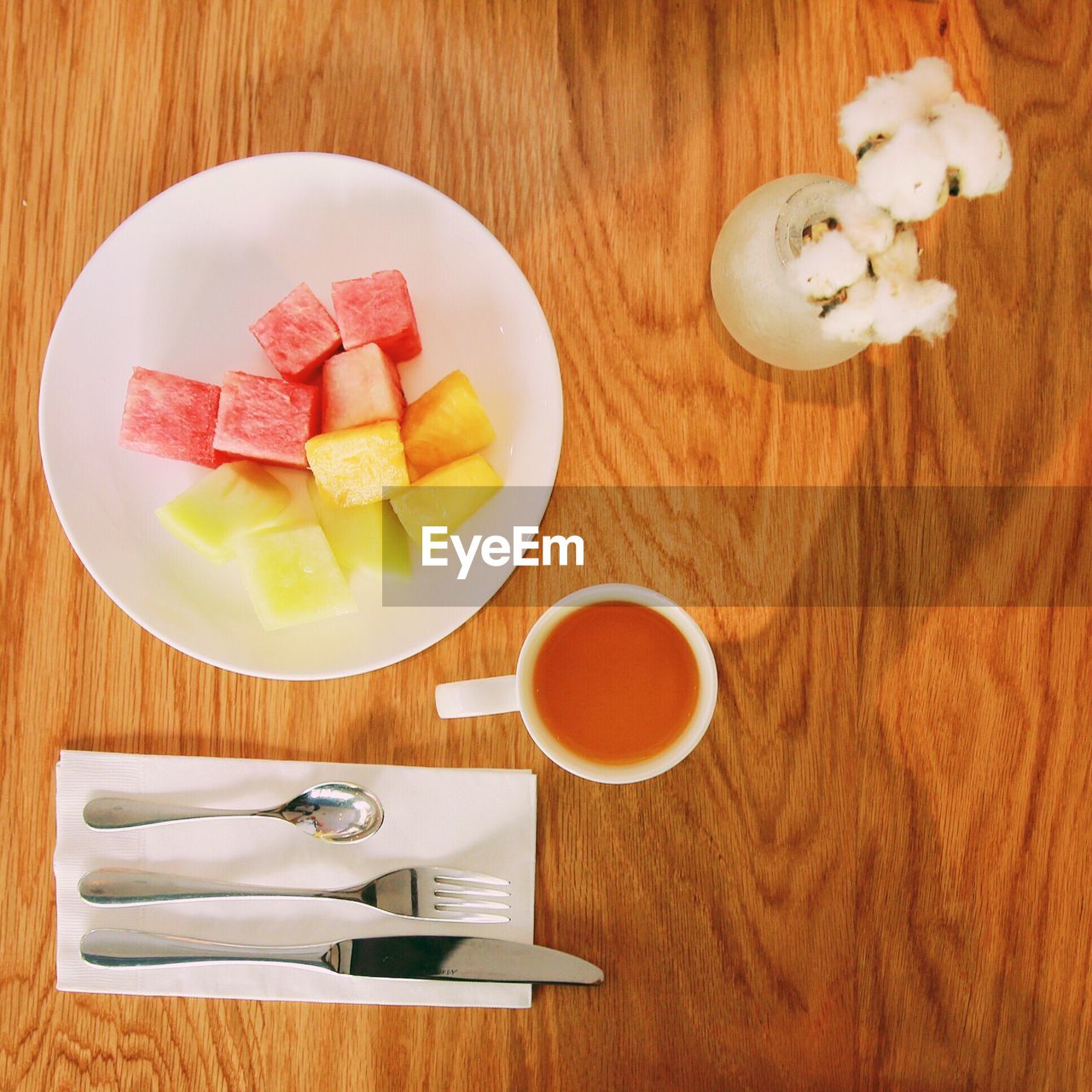 Directly above shot of fruit salad served with tea on table