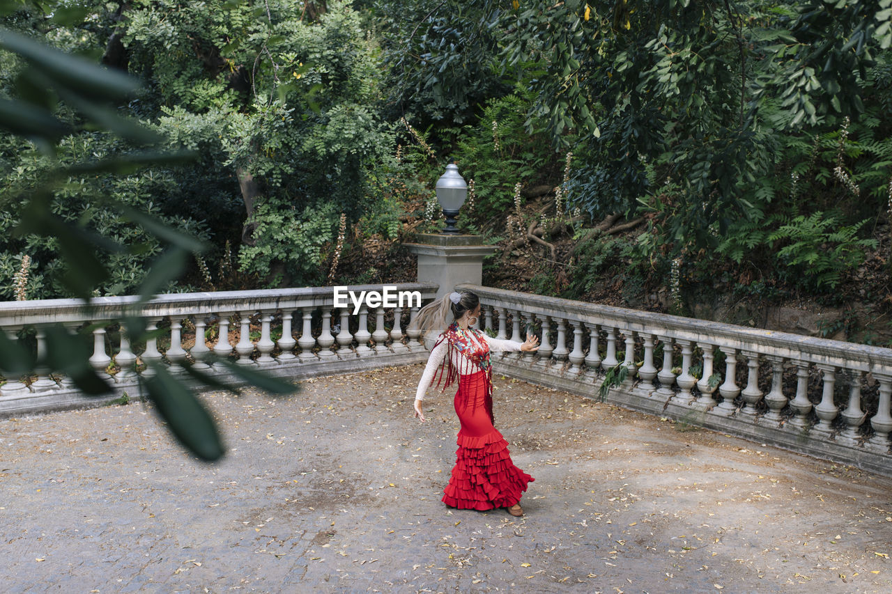 Female dancer dancing near in front of trees