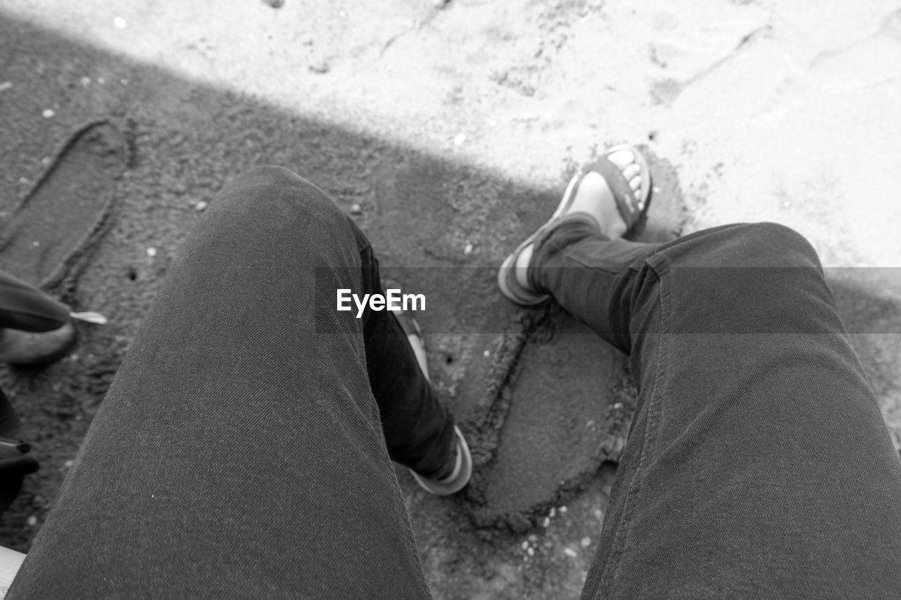 human leg, black, low section, personal perspective, shoe, black and white, one person, high angle view, lifestyles, white, monochrome photography, monochrome, footwear, limb, leisure activity, day, human limb, men, adult, hand, human foot, casual clothing, relaxation, nature, outdoors, women