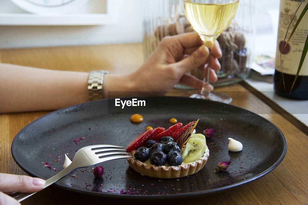 Midsection of woman with idessert on plate