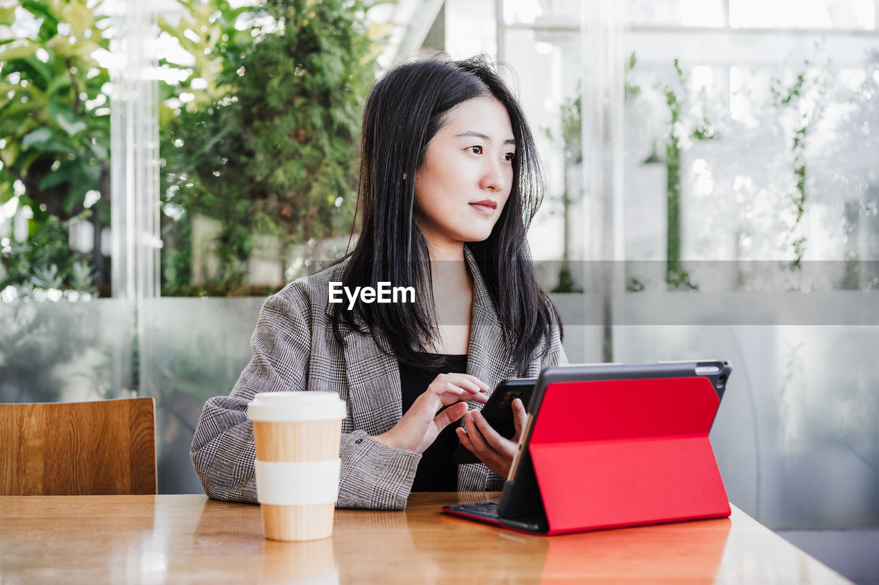 Professional chinese entrepreneur woman working on laptop in cafeteria. technology, lifestyle