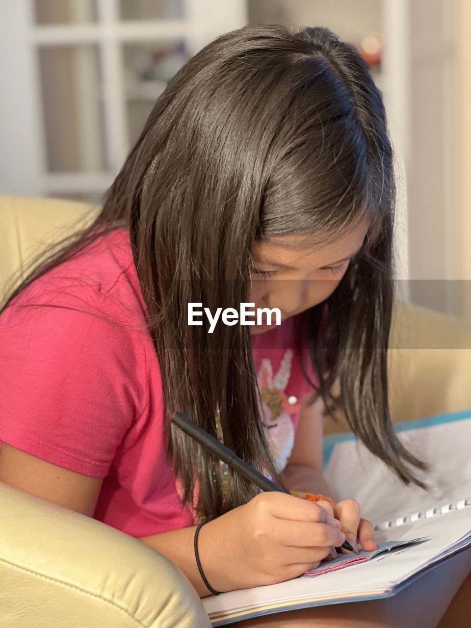 side view of girl using laptop at home