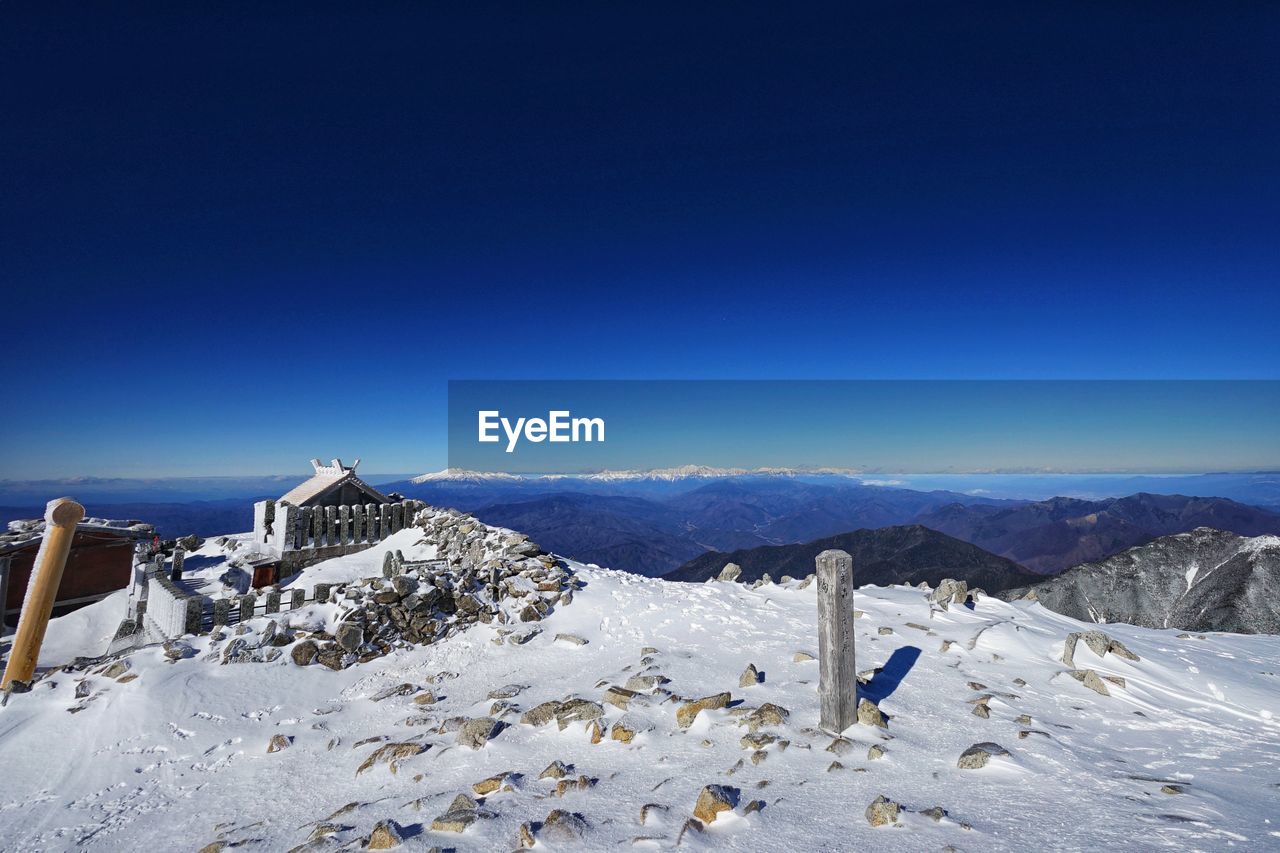 Scenic view of snowcapped mountains against clear blue sky