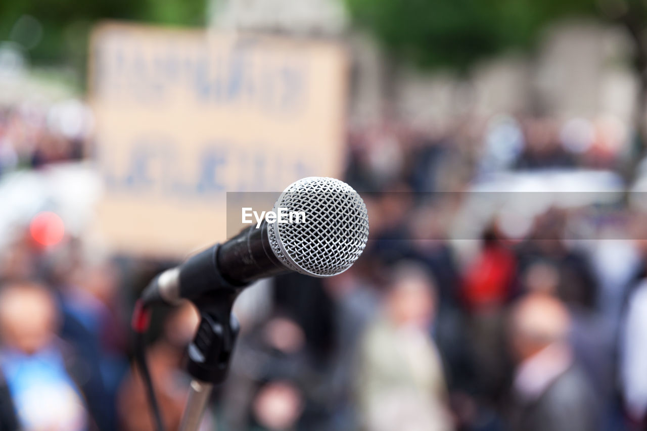 Close-up of microphone against crowd in city