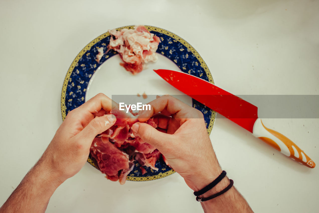 CLOSE-UP OF MAN HOLDING FOOD