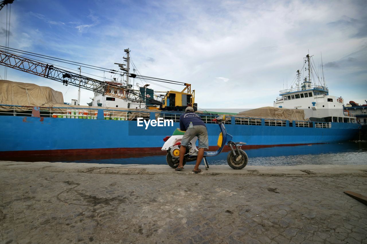 MAN WITH BICYCLE AGAINST SEA