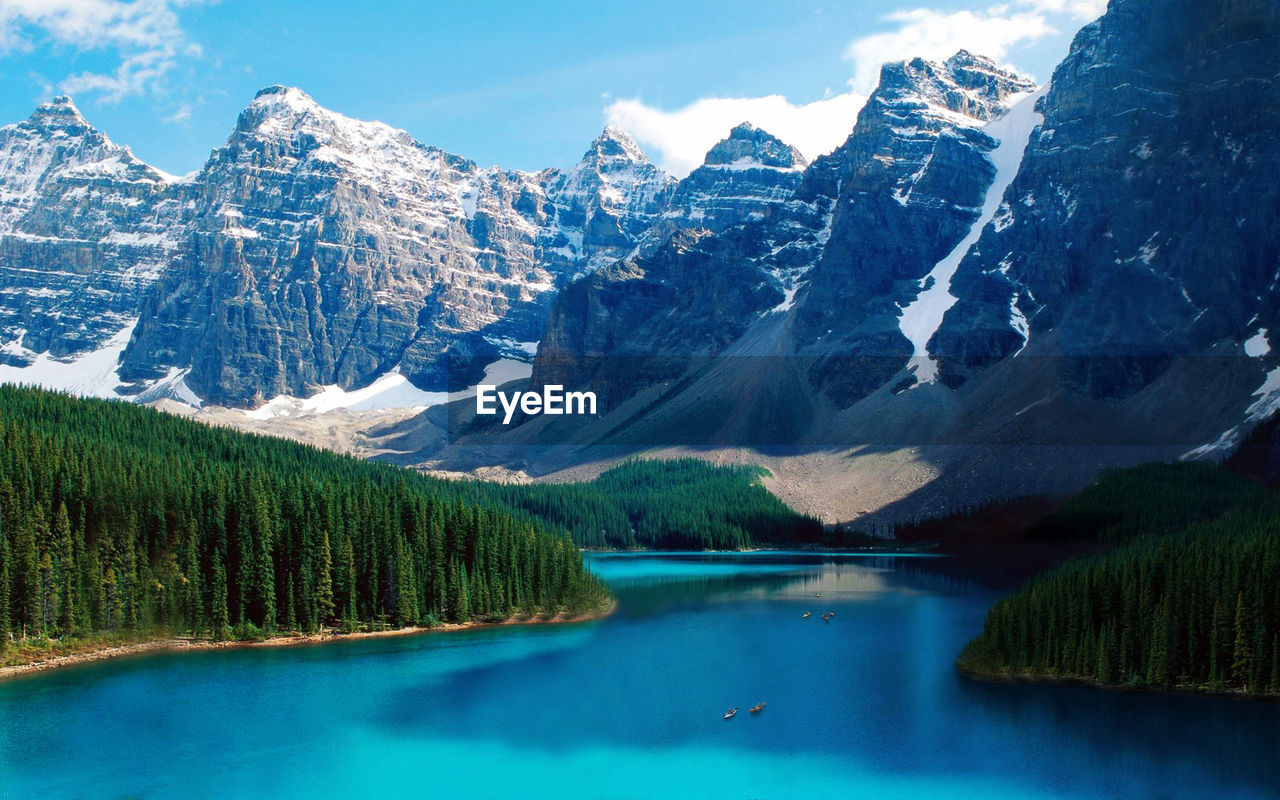 Scenic view of river by snow covered mountains