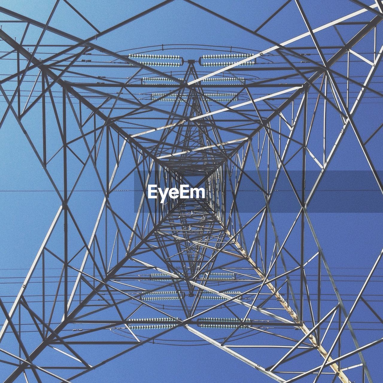 Electricity pylon against blue sky