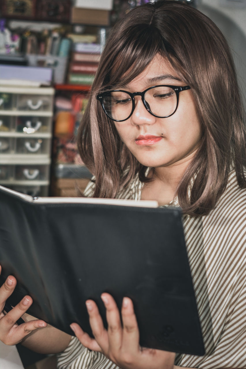 Portrait of a young girl reading a book with leather cover