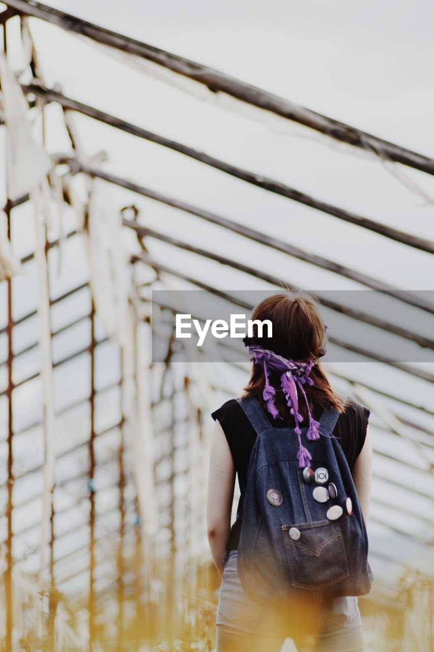 Low angle view of woman standing with backpack
